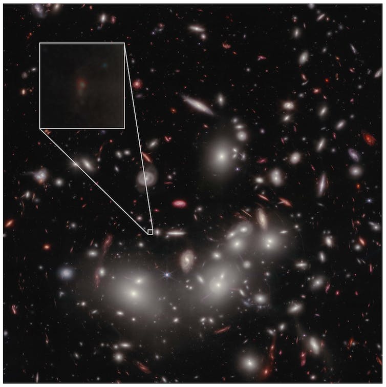 Bright lights (galaxies and some stars) against a dark background of the sky.  A faint galaxy is shown in a magnified box as a dim spot.